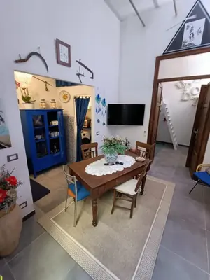 a living room with a wooden table and chairs at Syd's House in Bagheria