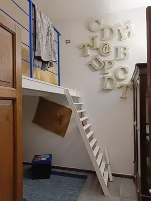 a room with a white shelf and a sign on the wall at Syd's House in Bagheria