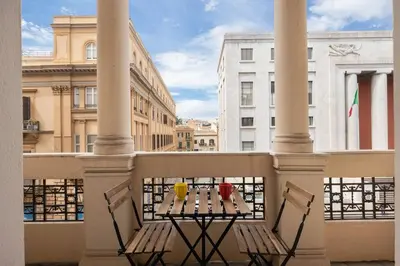a balcony with a table and two drinks on a balcony at Ninni's House by DomuSicily in Palermo