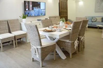 a dining room with a white table and wicker chairs at Villa Rosina in Cinisi