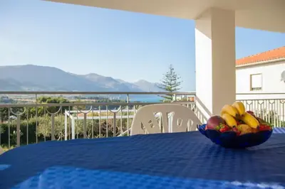 a kitchen and living room with a table and chairs at Villa Corallo Sicily - Scopello Guidaloca Bay in Scopello