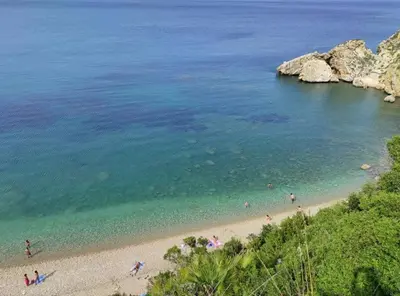 a group of people on a beach near the water at Villa Corallo Sicily - Scopello Guidaloca Bay in Scopello