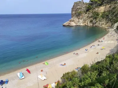 a beach with a bunch of people in the water at Villa Corallo Sicily - Scopello Guidaloca Bay in Scopello
