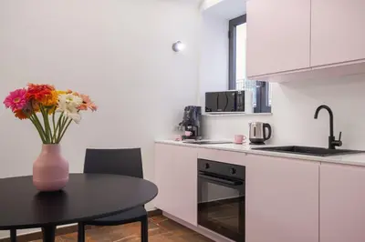 a kitchen with a table and a vase with flowers on it at A Casa di Giulia - elegante loft in centro storico in Palermo