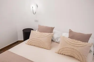 a white bed with pillows on top of it at A Casa di Giulia - elegante loft in centro storico in Palermo