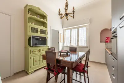 a dining room with a table and a green cabinet at Appartamento a due passi da Villa Trabia by Wonderful Italy in Palermo