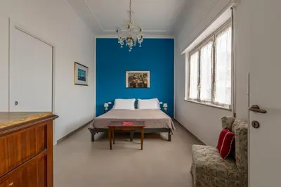 a bedroom with a bed with a blue wall at Appartamento a due passi da Villa Trabia by Wonderful Italy in Palermo