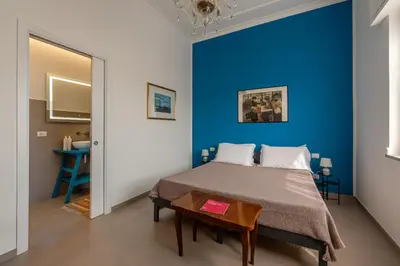 a blue bedroom with a bed and a table at Appartamento a due passi da Villa Trabia by Wonderful Italy in Palermo