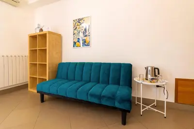 a blue couch in a room with a table at Kanisa Mari e Monti in Cinisi