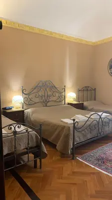 a bedroom with two beds and two lamps on the wall at Laura Affittacamere in Palermo
