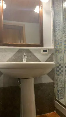 a bathroom with a white sink and a mirror at Laura Affittacamere in Palermo