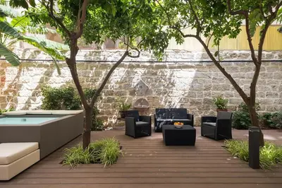 a patio with chairs and a pool and trees at The Garden Boutique Apartment by DomuSicily in Palermo