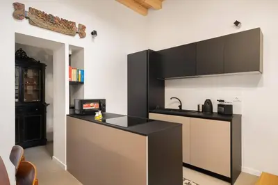 a kitchen with a black counter top in a room at The Garden Boutique Apartment by DomuSicily in Palermo