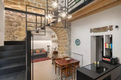 a living room with a spiral staircase in a house at The Garden Boutique Apartment by DomuSicily in Palermo