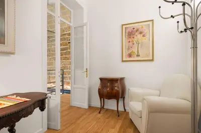 a living room with a table and a chair at The Garden Boutique Apartment by DomuSicily in Palermo