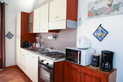 a small kitchen with a stove and a microwave at Cattedrale - VISTA HOUSE easy parking in Palermo