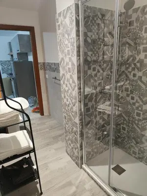 a shower with a glass door in a room at Casa Josè Suite Mare in Palermo