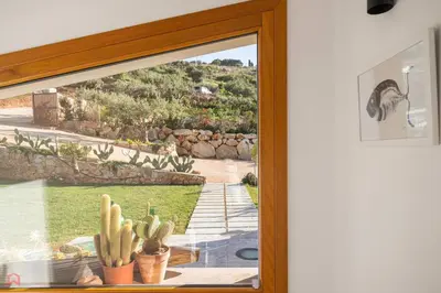 a sliding glass door with a view of a yard at Sea View Villa whit Pool in Scopello