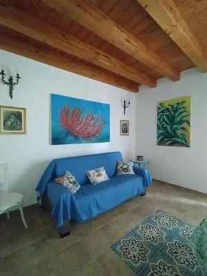 a living room with a blue couch in a room at Casa Lo Re in Santa Flavia