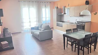 a kitchen and living room with a table and a couch at Proserpina House in Palermo