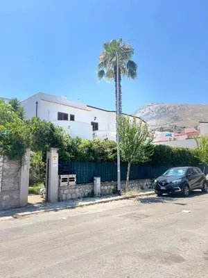 a car parked in a parking lot with a palm tree at Proserpina House in Palermo