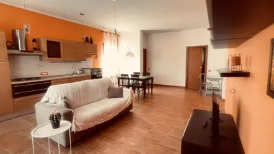 a living room with a white couch and a kitchen at Proserpina House in Palermo