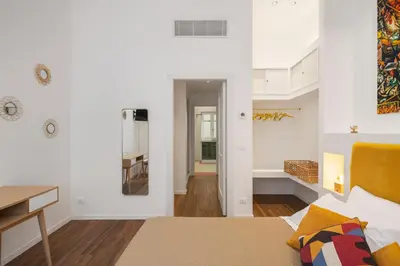a bedroom with a bed and a desk and a mirror at Casa Brezi in Palermo