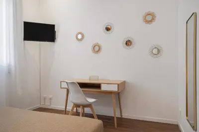 a bedroom with a desk and a table with a chair at Casa Brezi in Palermo