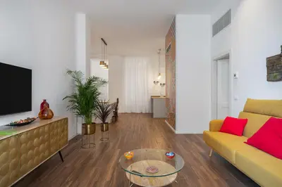 a living room with a yellow couch and a table at Casa Brezi in Palermo