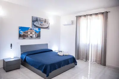 a bedroom with a blue bed and a window at Casa vacanze Rigano Palermo in Palermo