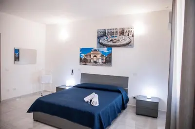 a bedroom with a bed with a blue blanket at Casa vacanze Rigano Palermo in Palermo
