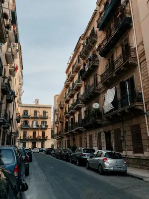 a street with cars parked on the sides of buildings at Casa vacanze Rigano Palermo in Palermo