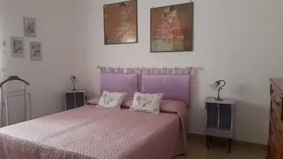 a bedroom with a pink bed with two pillows at La comodità a due passi dal mare di Mondello in Mondello