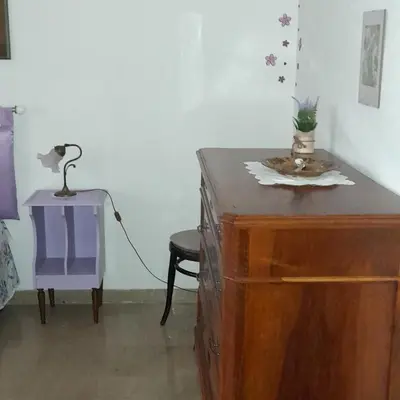 a dresser with a lamp on it next to a chair at La comodità a due passi dal mare di Mondello in Mondello