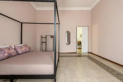 a bedroom with a canopy bed and a hallway at Stylish apartment near Piazza Magione by Wonderful Italy in Palermo