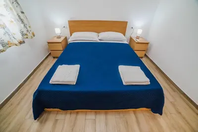 a bedroom with a blue bed with two night stands at Villa delle Palme in Campofelice di Roccella