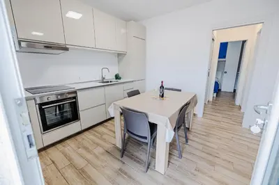 a kitchen and dining room with a table and chairs at Villa delle Palme in Campofelice di Roccella