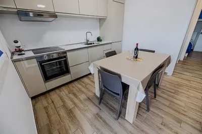 a kitchen with a table with chairs and a sink at Villa delle Palme in Campofelice di Roccella