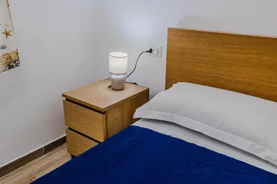 a bedroom with a bed with a wooden head board at Villa delle Palme in Campofelice di Roccella