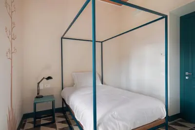 a bedroom with a canopy bed with a lamp and a table at Casa San Francesco Rooms in Palermo