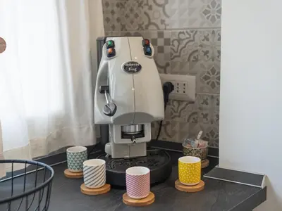 a coffee machine sitting on a counter with cups at Central Station Home - Fanale Rentals in Palermo
