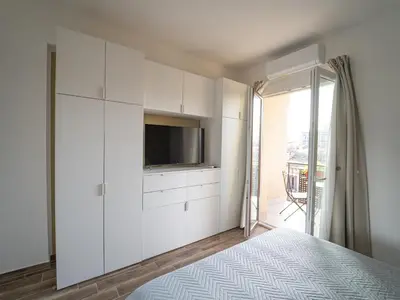 a bedroom with white cabinets and a tv on a wall at Central Station Home - Fanale Rentals in Palermo