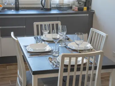 a dining table with glasses and plates on it at Central Station Home - Fanale Rentals in Palermo