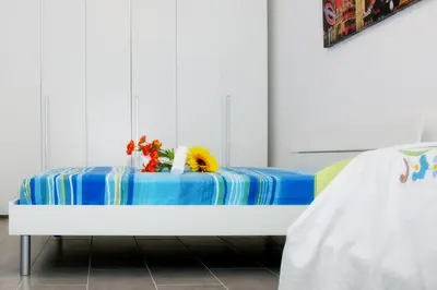 a bed with flowers and vases on it at Casa Longo 2 in Castellammare del Golfo