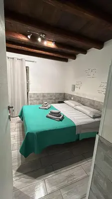 a room with a bed with a green table at La casetta del borgo in Palermo