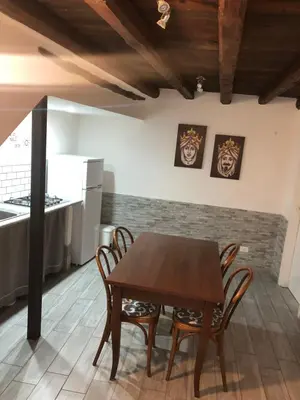 a kitchen with a table and chairs in a room at La casetta del borgo in Palermo