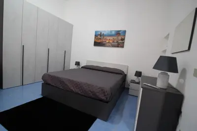 a bedroom with a bed and a cabinet and a lamp at Case Billeci Casa blu in Palermo