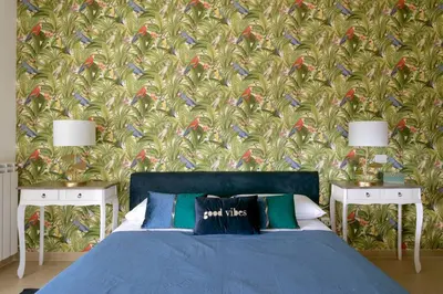 a bedroom with a blue bed and a wall with birds at Villa Marina Sant'Elia in Santa Flavia
