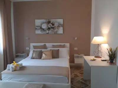 a bedroom with a large white bed and a table at Politeama Center in Palermo