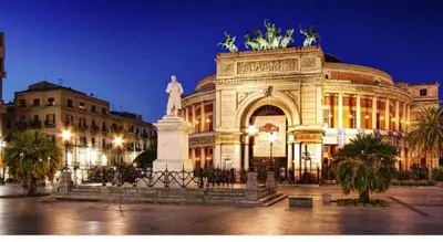 a large building with a statue in front of it at Politeama Center in Palermo
